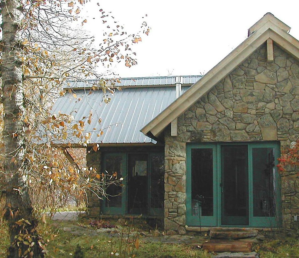 Foto della facciata di una casa piccola classica a un piano con rivestimento in pietra