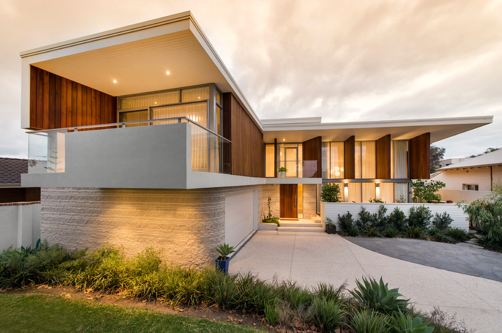 Cette image montre une façade de maison minimaliste de taille moyenne et à un étage avec un toit plat.