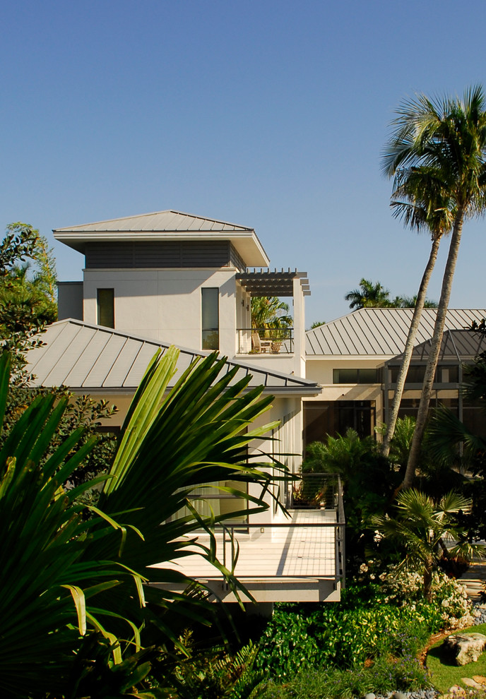 Example of a huge minimalist white one-story mixed siding exterior home design in Miami with a hip roof
