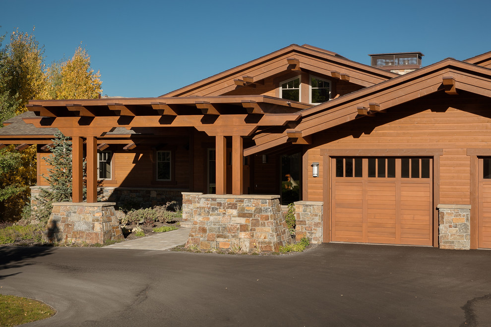 Cette photo montre une grande façade de maison marron tendance en bois à un étage avec un toit à deux pans.