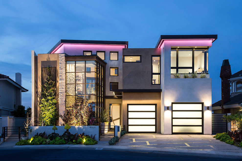 Imagen de fachada de casa multicolor actual de dos plantas con tejado plano y revestimiento de estuco