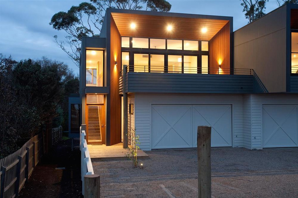 Imagen de fachada de casa contemporánea grande de dos plantas con revestimiento de madera y tejado de metal