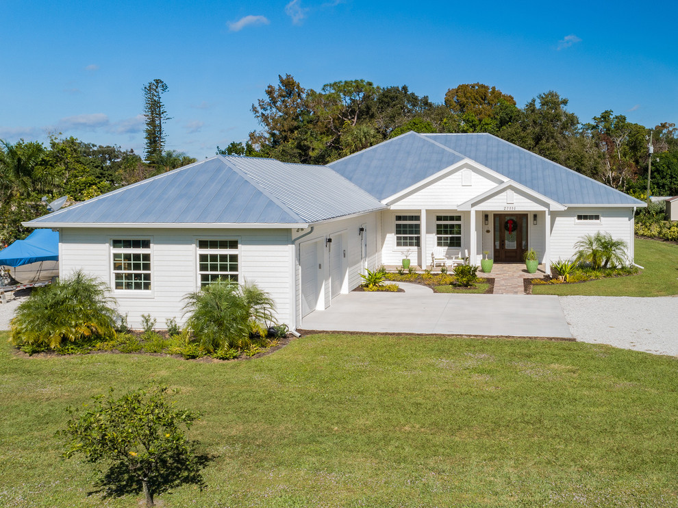 Mid-sized elegant white one-story vinyl house exterior photo in Other with a metal roof