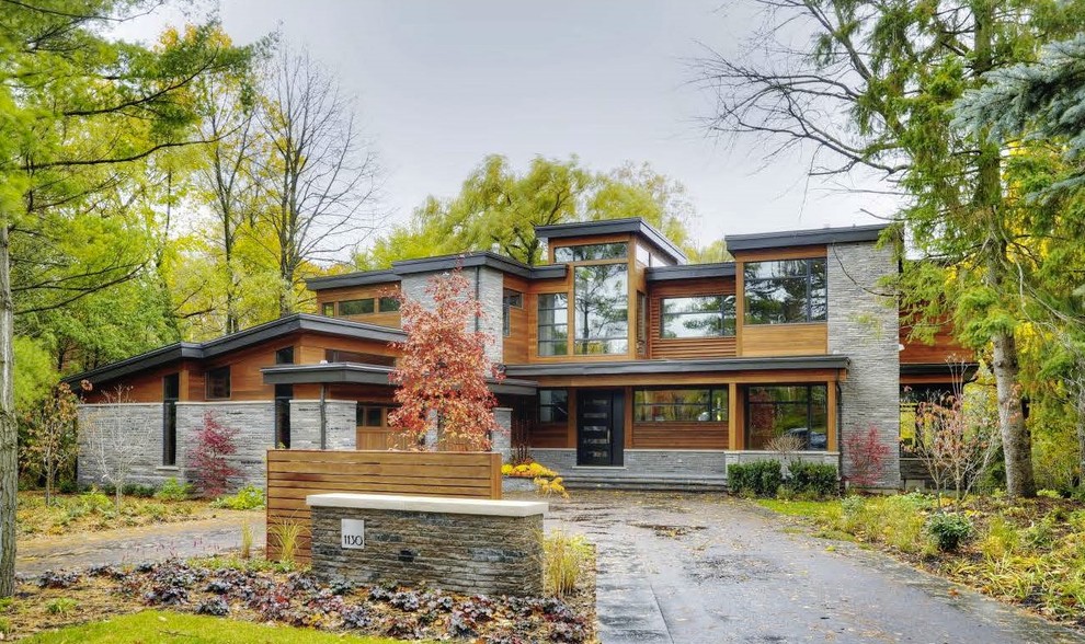 Photo of a large contemporary detached house in Toronto with three floors, mixed cladding, a flat roof and a metal roof.
