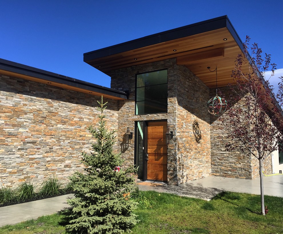 Mittelgroßes, Einstöckiges Modernes Einfamilienhaus mit Steinfassade, beiger Fassadenfarbe und Pultdach in Calgary