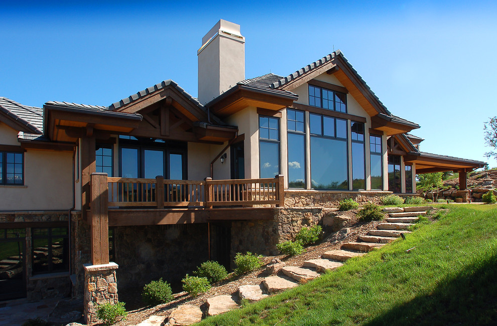 Inspiration for a huge rustic beige two-story mixed siding exterior home remodel in Denver