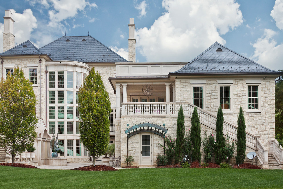 Inspiration for an expansive and beige traditional house exterior in Charlotte with three floors and stone cladding.
