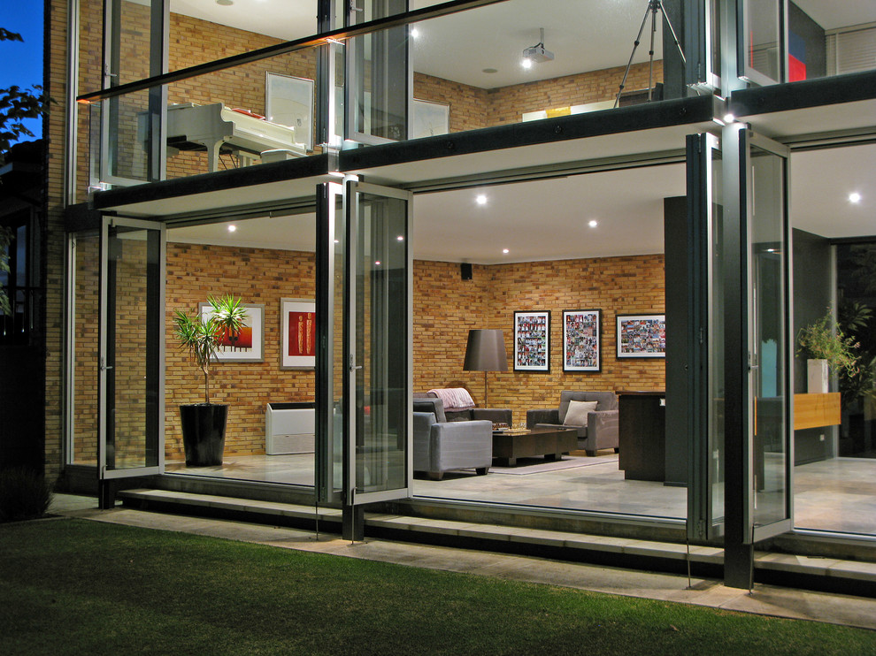 Esempio della facciata di una casa contemporanea con rivestimento in vetro