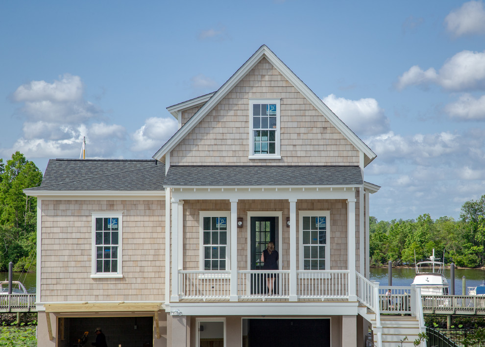Imagen de fachada de casa beige clásica pequeña de tres plantas con revestimiento de madera, tejado a dos aguas y tejado de teja de madera