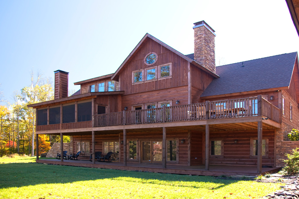 This is an example of a large and brown rustic two floor house exterior in Other with wood cladding and a pitched roof.