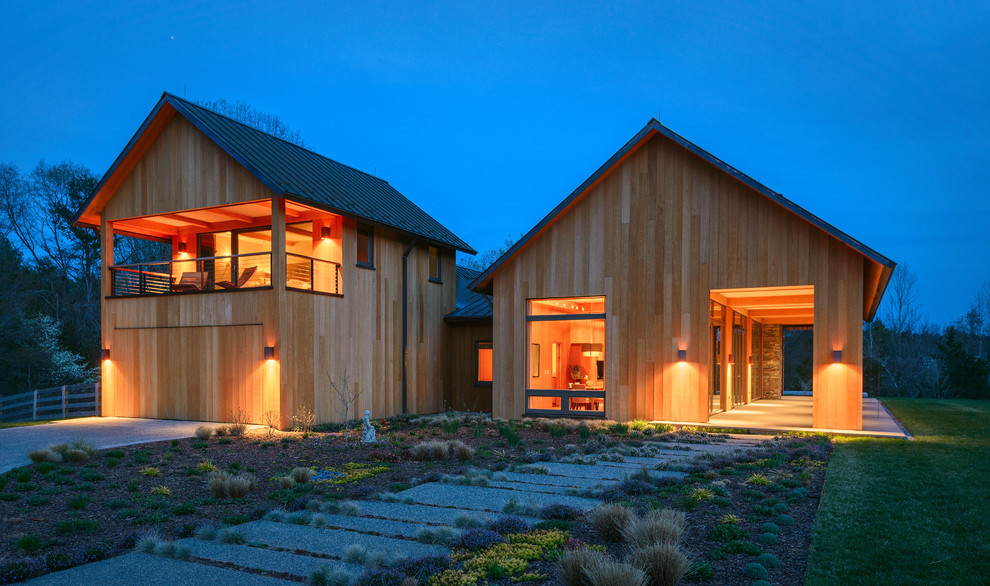 Idées déco pour une grande façade de maison jaune moderne en bois à un étage avec un toit à deux pans et un toit en métal.