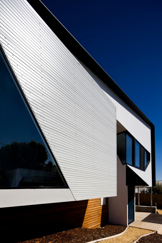 Diseño de fachada negra contemporánea pequeña de dos plantas con revestimiento de metal y tejado de un solo tendido