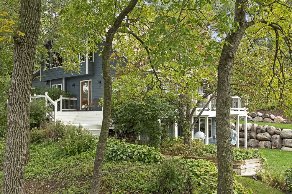 Идея дизайна: большой, двухэтажный, синий дом в классическом стиле с облицовкой из винила и односкатной крышей