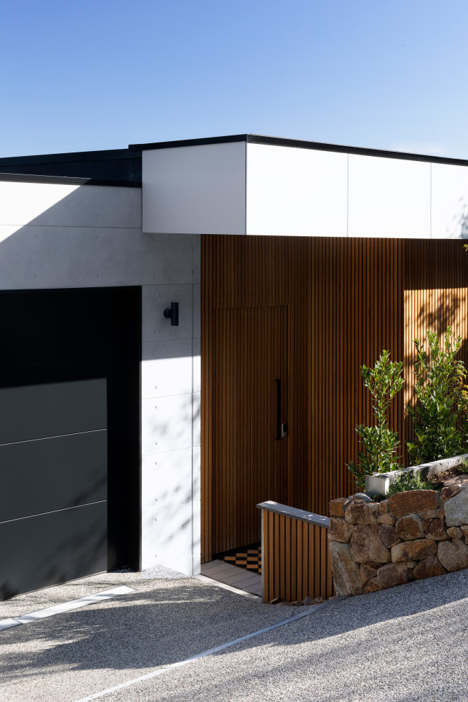Large contemporary gray split-level concrete fiberboard exterior home idea in Melbourne with a metal roof