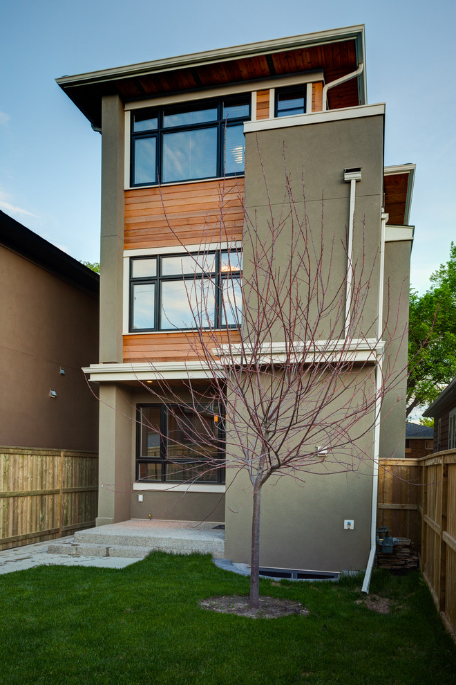 Medium sized and brown contemporary two floor house exterior in Calgary with wood cladding.