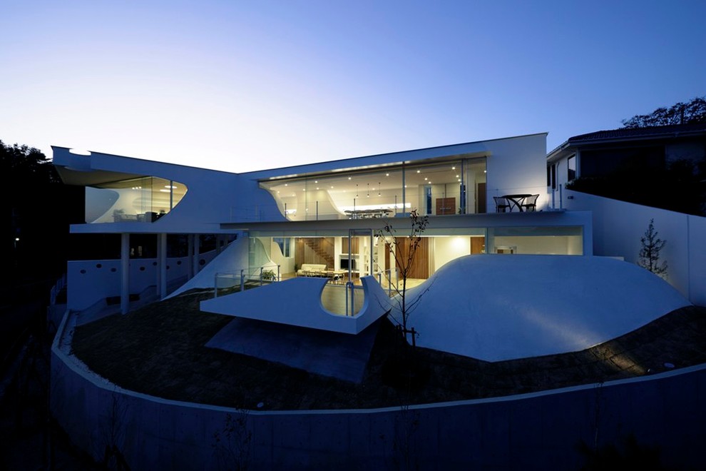 Aménagement d'une façade de maison blanche contemporaine à un étage avec un toit plat.