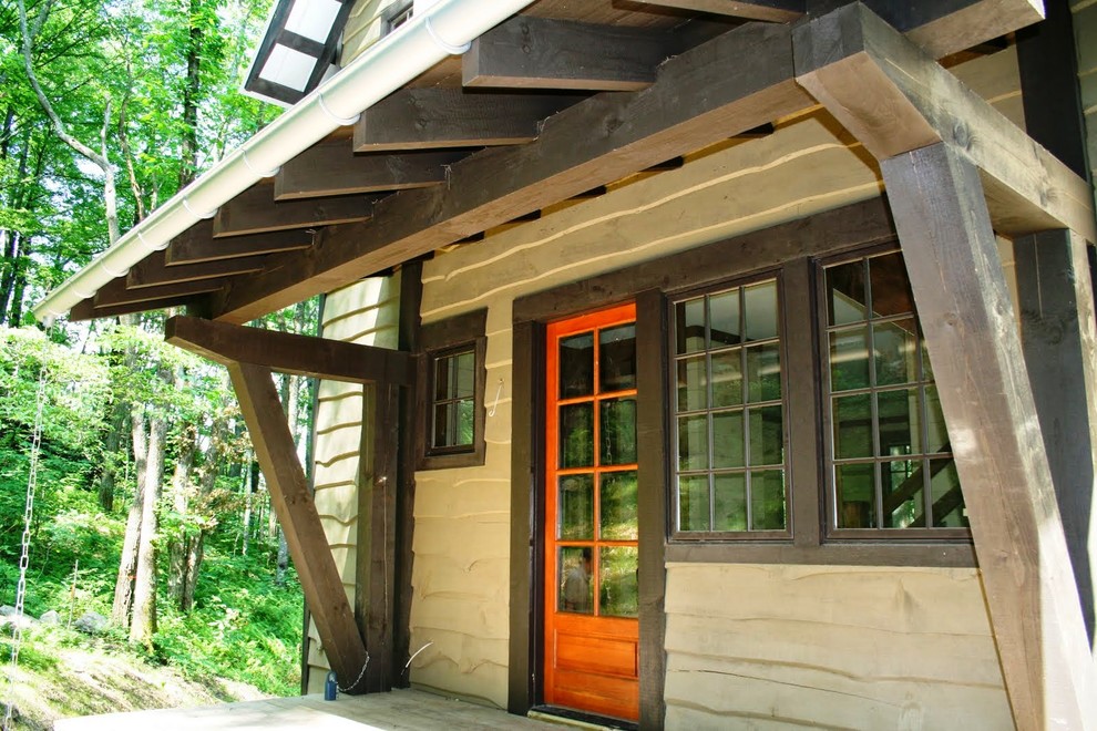 Diseño de fachada beige rústica de tamaño medio de dos plantas con revestimiento de madera y tejado a dos aguas