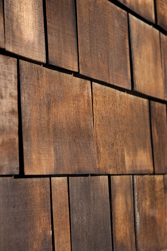 Foto de fachada de casa marrón rústica de tamaño medio de una planta con revestimiento de madera, tejado de un solo tendido y tejado de teja de madera