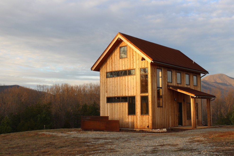 Ispirazione per la villa piccola marrone rustica a due piani con rivestimento in legno, tetto a capanna e copertura in metallo o lamiera