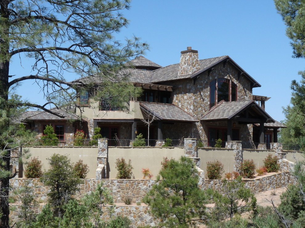 Example of a huge mountain style brown two-story mixed siding gable roof design in Phoenix