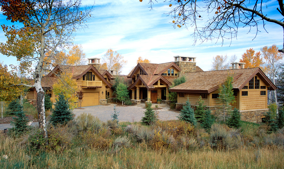 Idee per la villa grande marrone rustica a due piani con rivestimento in legno e tetto a capanna