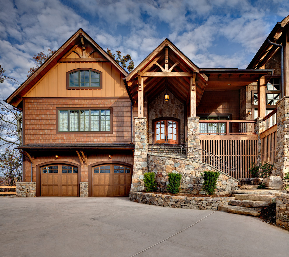 Exemple d'une très grande façade de maison marron montagne en bois à un étage avec un toit à deux pans.