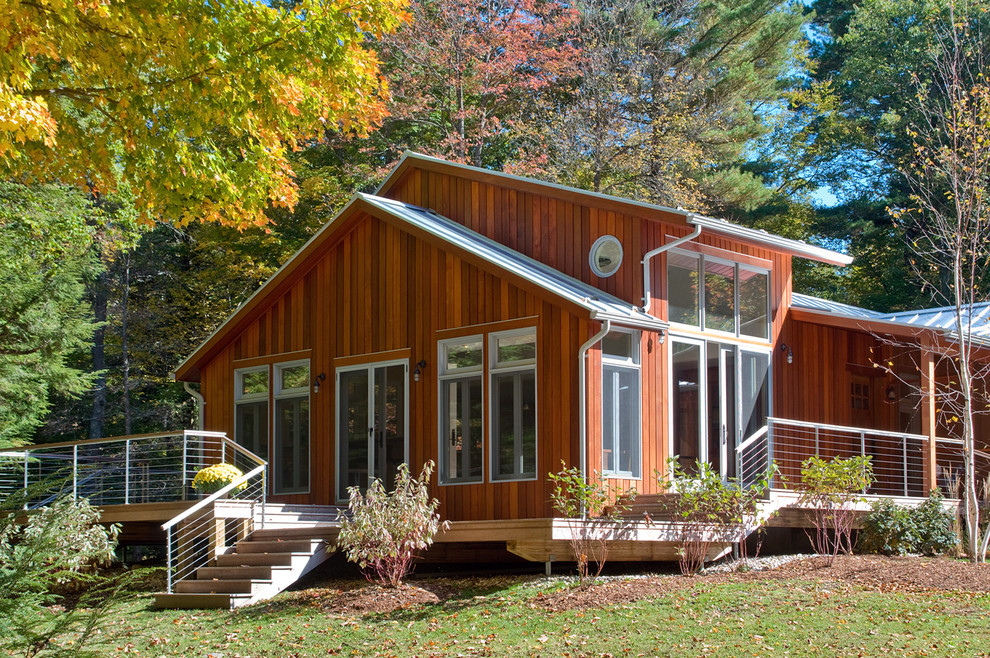 Idée de décoration pour une grande façade de maison marron design en bois de plain-pied avec un toit à deux pans et un toit en métal.
