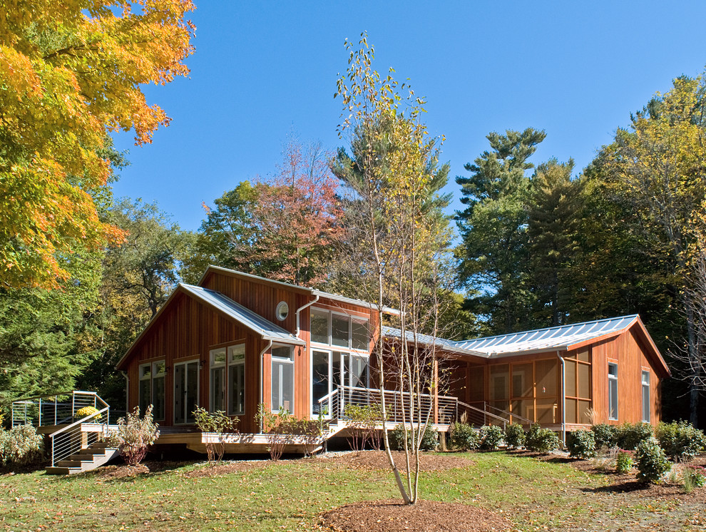 Réalisation d'une grande façade de maison marron design en bois de plain-pied avec un toit à deux pans et un toit en métal.