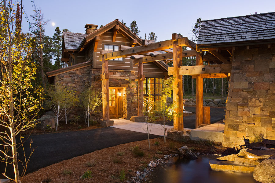Inspiration for a large rustic brown two-story stone house exterior remodel in Other with a shingle roof