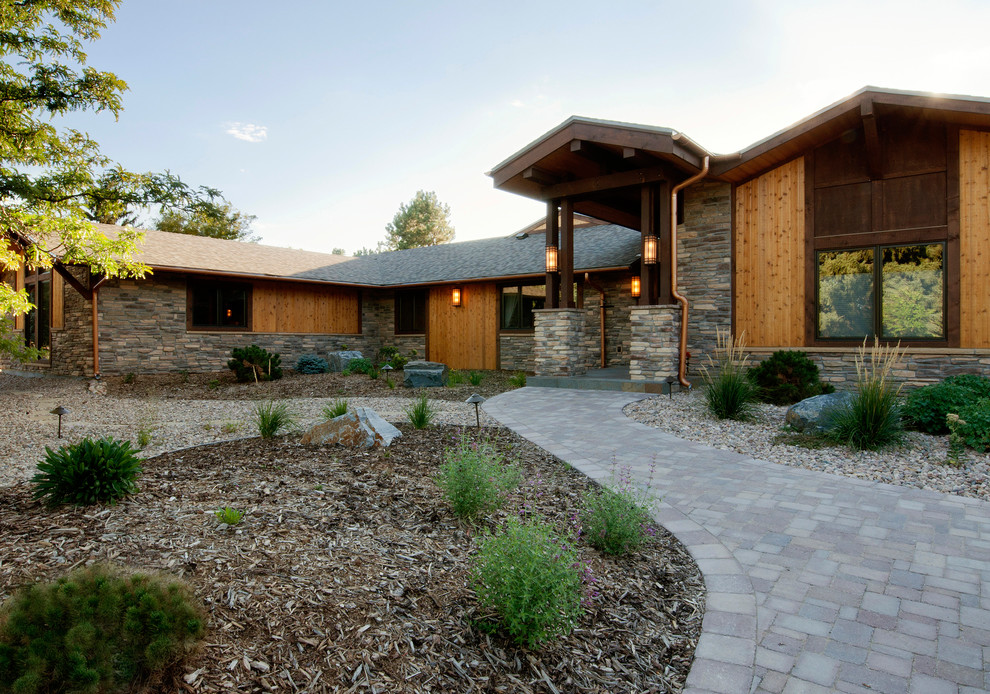 Imagen de fachada marrón de estilo americano de una planta con revestimiento de piedra y tejado a dos aguas