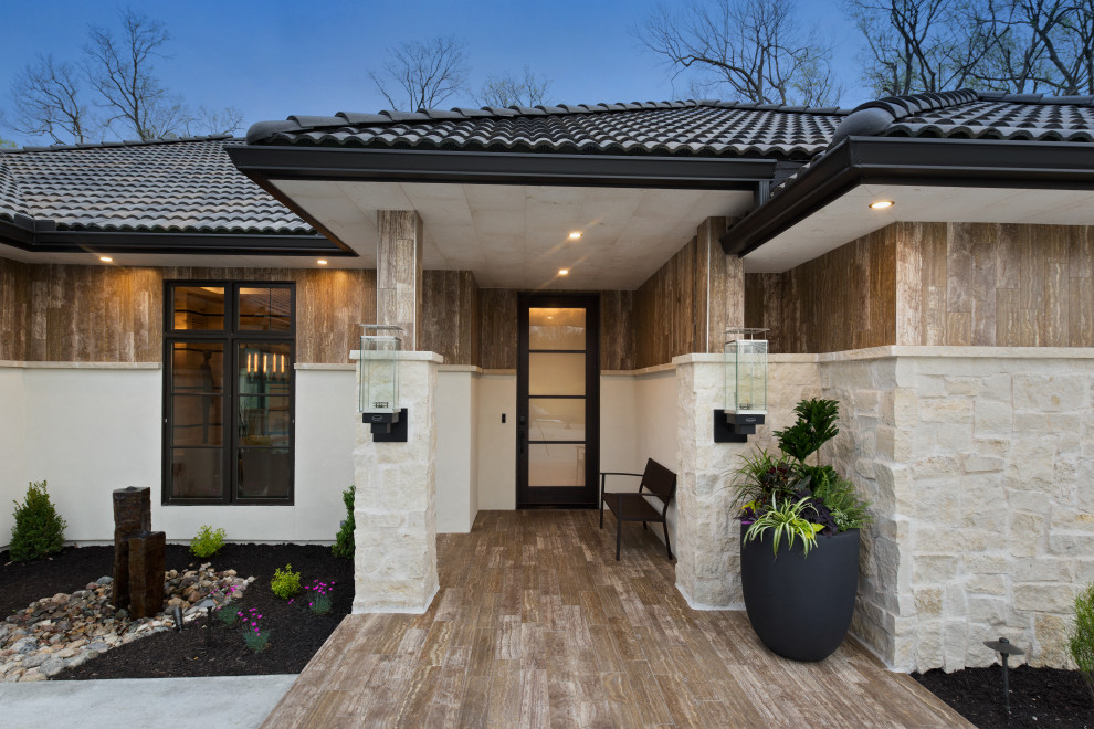 Inspiration for a modern beige one-story stone house exterior remodel in Kansas City with a hip roof and a tile roof