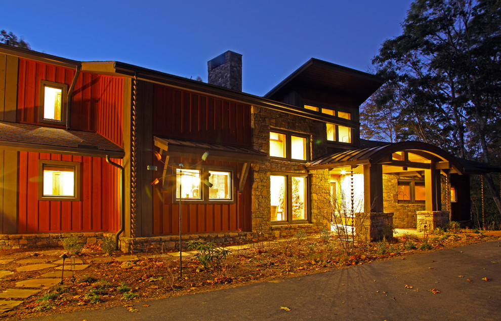 Cette image montre une grande façade de maison marron design en bois à deux étages et plus avec un toit en appentis et un toit en shingle.