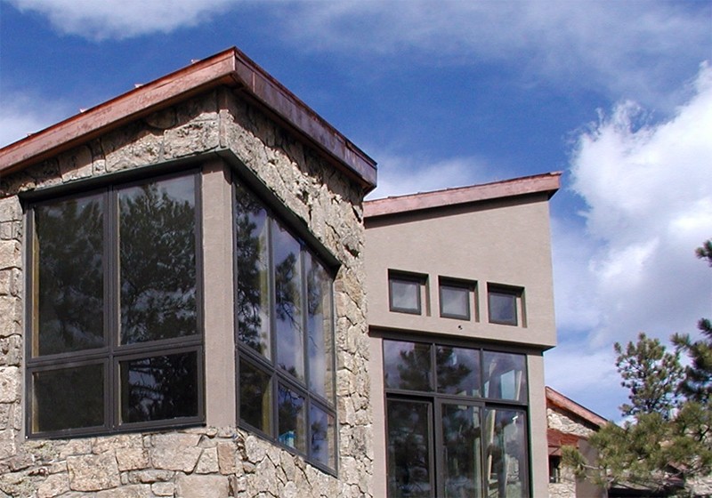 Inspiration for a mid-sized modern gray one-story stone exterior home remodel in Denver with a shed roof