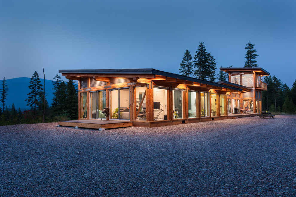 Стильный дизайн: двухэтажный, стеклянный, коричневый частный загородный дом в современном стиле с односкатной крышей и металлической крышей - последний тренд