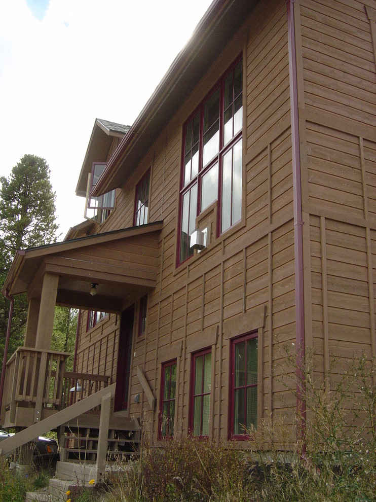Foto de fachada de casa marrón actual pequeña de dos plantas con revestimiento de madera, tejado a dos aguas y tejado de teja de madera