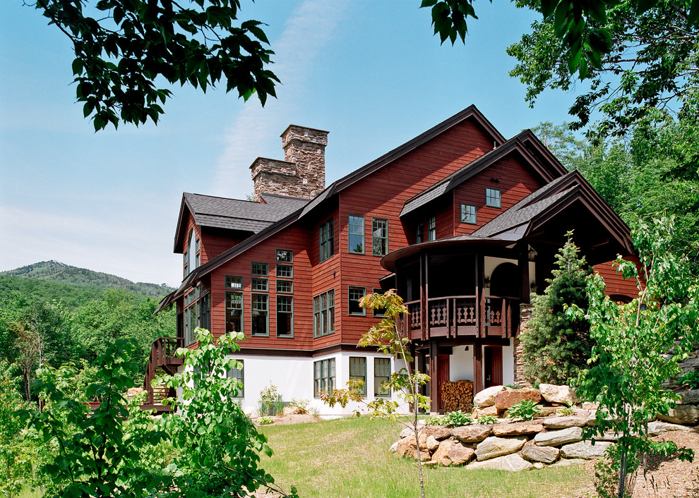 Idée de décoration pour une grande façade de maison marron chalet en bois à deux étages et plus avec un toit à deux pans.