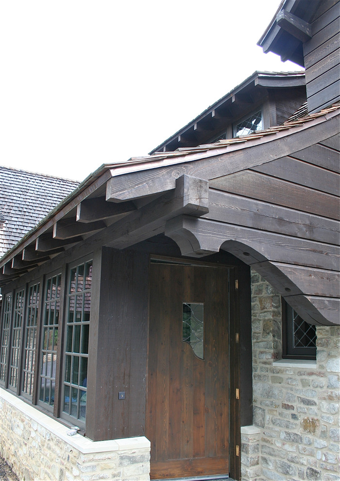Imagen de fachada marrón clásica de tres plantas con revestimiento de madera