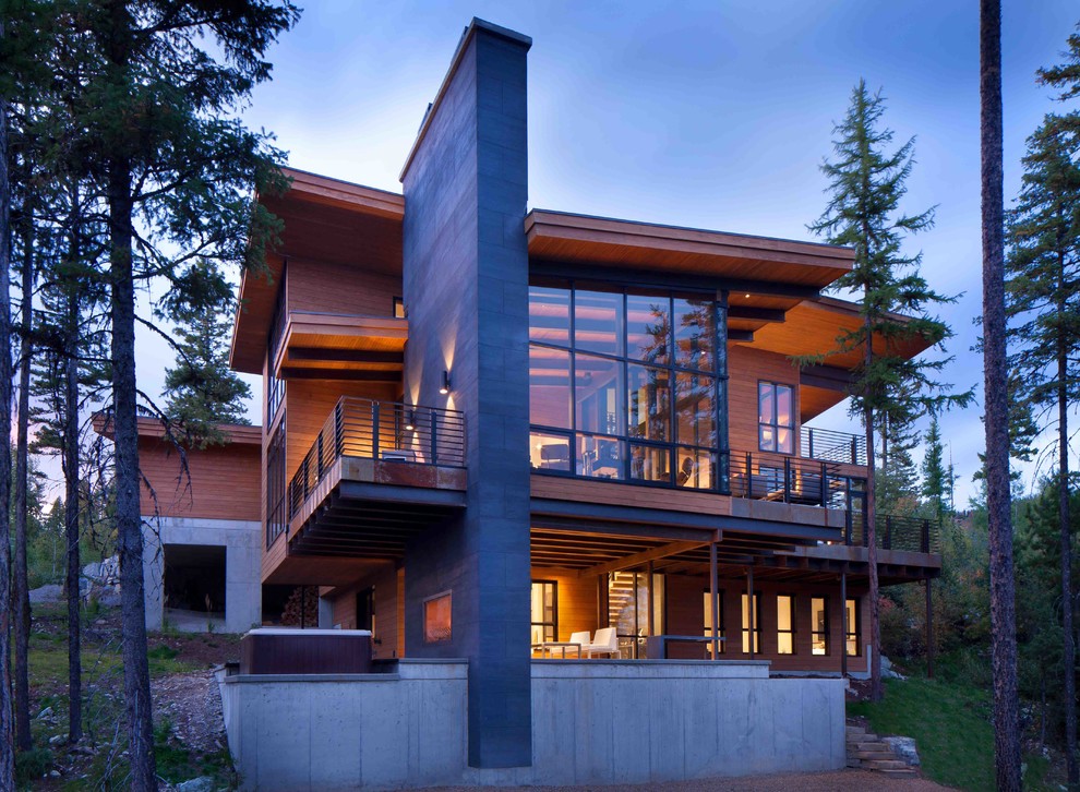Immagine della facciata di una casa ampia marrone moderna a due piani con rivestimento in vetro