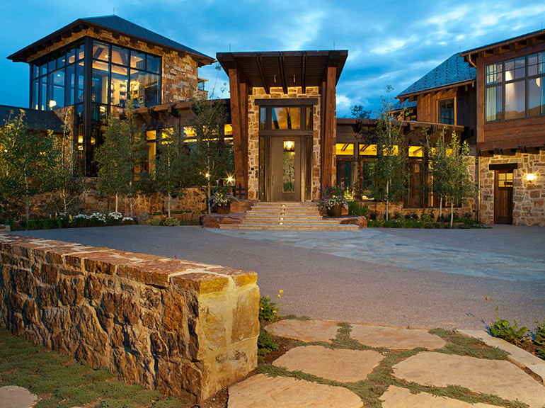 Example of a huge trendy brown three-story stone exterior home design in Denver with a hip roof