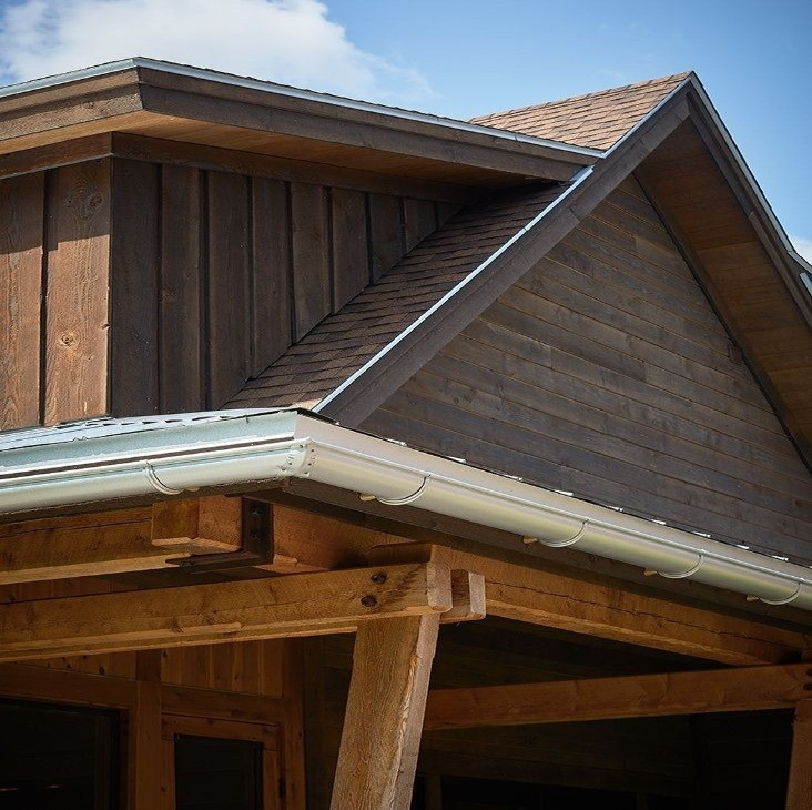 Ejemplo de fachada de casa marrón rústica con revestimiento de madera y tejado de teja de madera