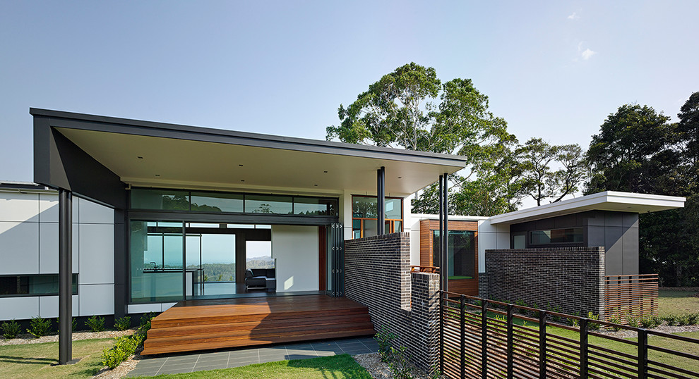This is an example of a white contemporary bungalow house exterior in Brisbane with a flat roof.