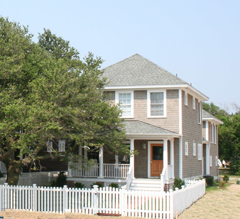 Cette photo montre une façade de maison grise chic en bois de taille moyenne et à un étage.