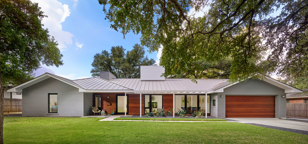 Einstöckiges Mid-Century Einfamilienhaus mit Mix-Fassade und grauer Fassadenfarbe in Austin