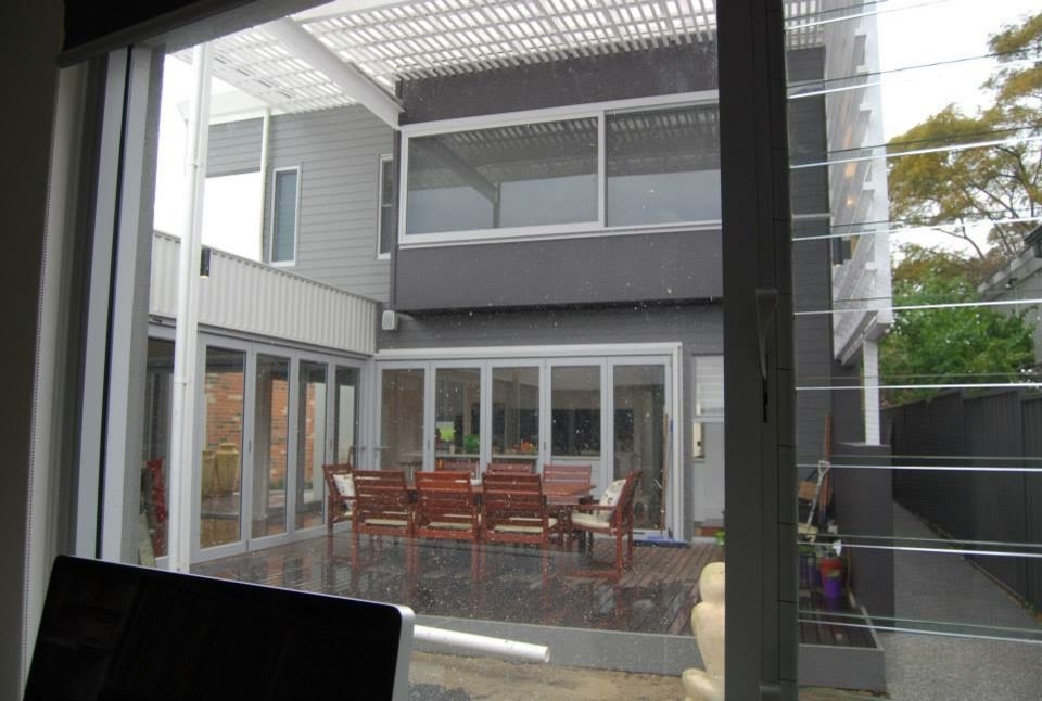 Imagen de fachada gris contemporánea grande de dos plantas con revestimiento de ladrillo y tejado a cuatro aguas