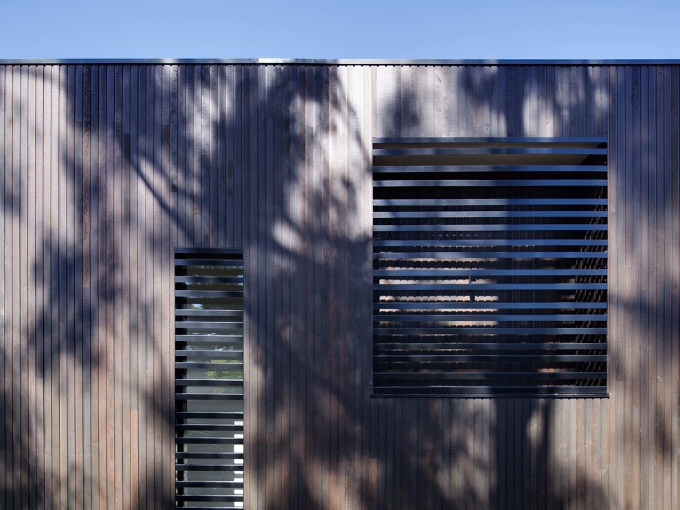 Inspiration for a large black three-story wood flat roof remodel in Melbourne