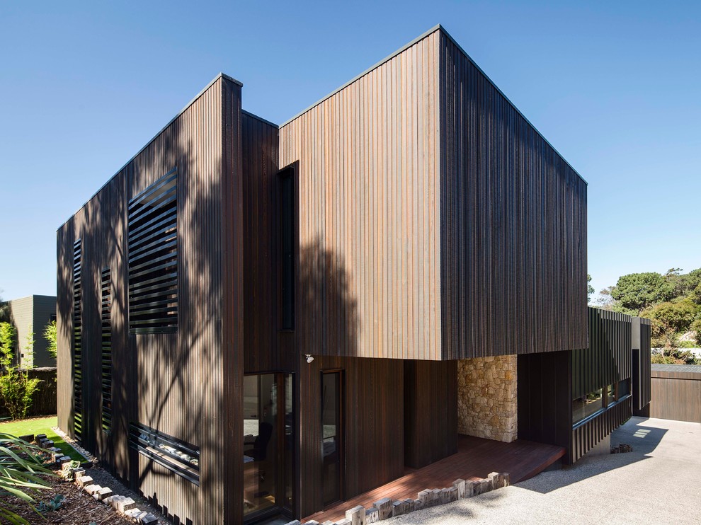 Example of a large black three-story wood flat roof design in Melbourne