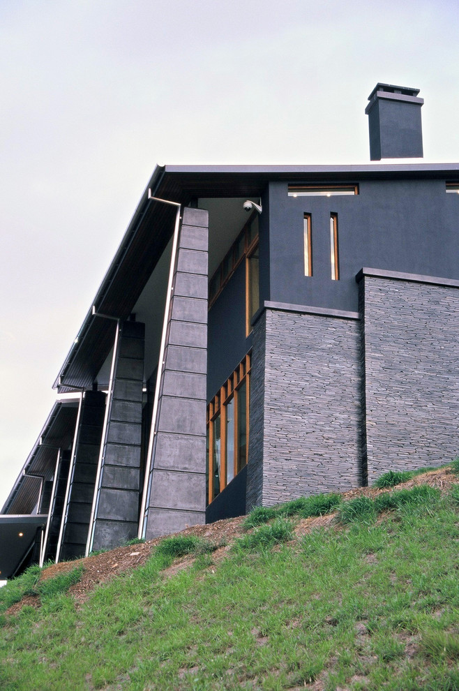 Ejemplo de fachada de casa negra de estilo zen extra grande de tres plantas con tejado plano y tejado de metal