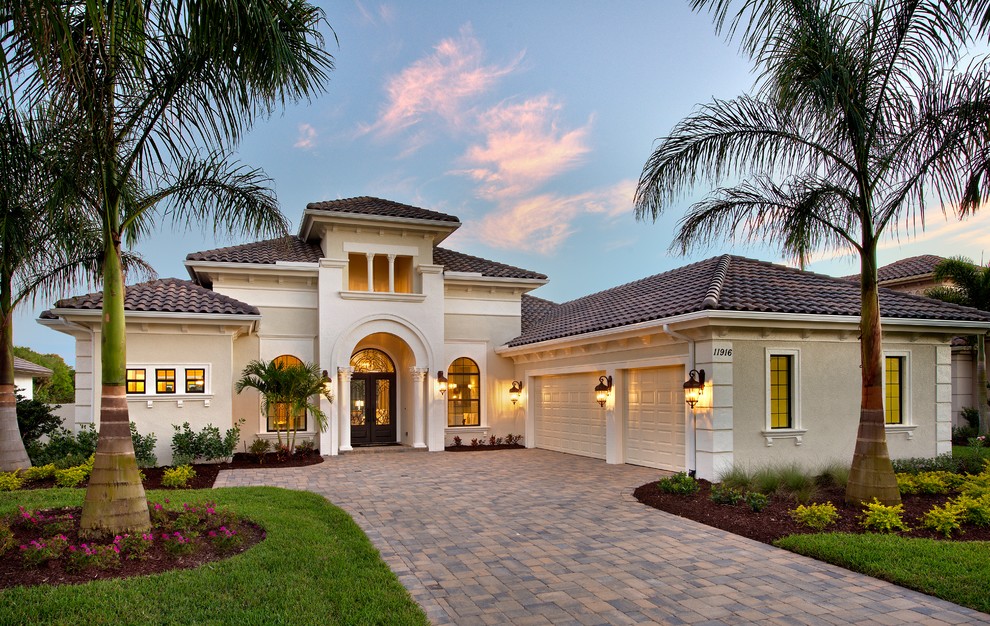 Inspiration for a mediterranean beige one-story exterior home remodel in Miami