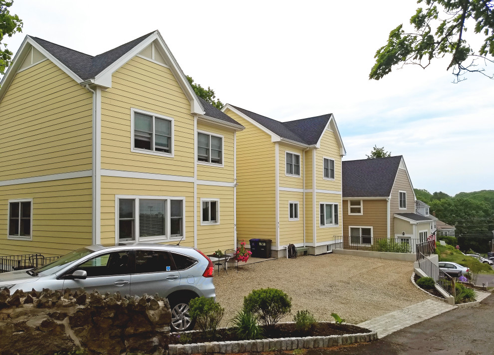 Mittelgroßes, Zweistöckiges Klassisches Wohnung mit Faserzement-Fassade, gelber Fassadenfarbe, Satteldach und Schindeldach in Boston