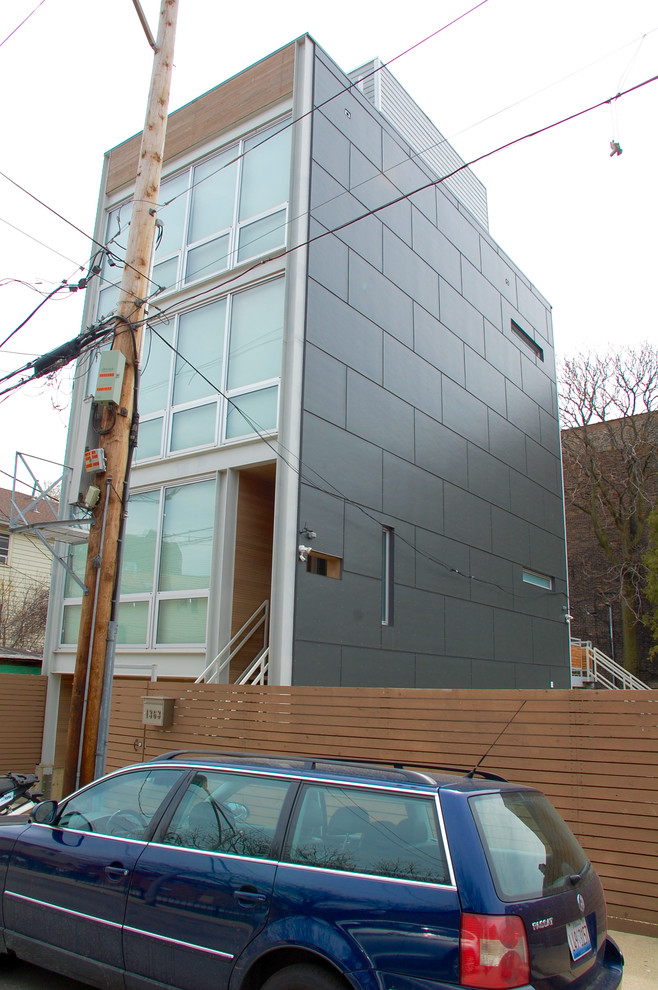 Cette photo montre une grande façade de maison grise industrielle en panneau de béton fibré à deux étages et plus avec un toit plat et un toit mixte.